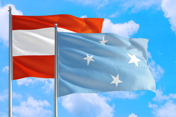 Micronesia and Austria national flag waving in the windy deep blue sky. Diplomacy and international relations concept.