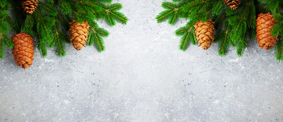 Christmas or New Year background with green fir branches and cones. Winter concept, top view, copy space.