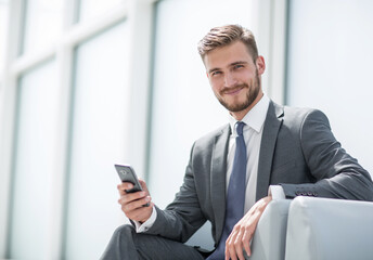 businessman sitting in an armchair with phone
