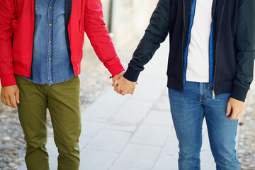 Gay couple holding hands in the street.