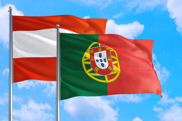 Portugal and Austria national flag waving in the windy deep blue sky. Diplomacy and international relations concept.