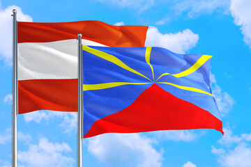 Reunion and Austria national flag waving in the windy deep blue sky. Diplomacy and international relations concept.