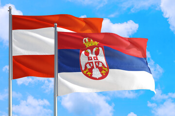 Serbia and Austria national flag waving in the windy deep blue sky. Diplomacy and international relations concept.