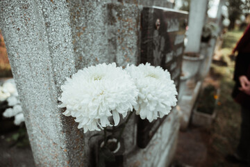 Gravestone in cemetery with flowers for concept of death and loss. All soul's day.