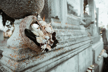 Gravestone in cemetery with flowers for concept of death and loss. All soul's day.