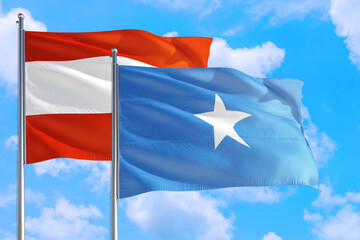 Somalia and Austria national flag waving in the windy deep blue sky. Diplomacy and international relations concept.