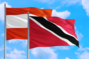 Trinidad And Tobago and Austria national flag waving in the windy deep blue sky. Diplomacy and international relations concept.