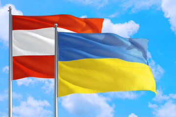 Ukraine and Austria national flag waving in the windy deep blue sky. Diplomacy and international relations concept.