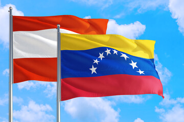 Venezuela and Austria national flag waving in the windy deep blue sky. Diplomacy and international relations concept.