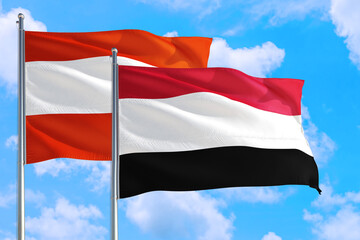 Yemen and Austria national flag waving in the windy deep blue sky. Diplomacy and international relations concept.