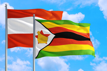 Zimbabwe and Austria national flag waving in the windy deep blue sky. Diplomacy and international relations concept.