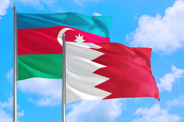 Bahrain and Azerbaijan national flag waving in the windy deep blue sky. Diplomacy and international relations concept.