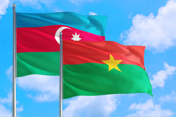 Burkina Faso and Azerbaijan national flag waving in the windy deep blue sky. Diplomacy and international relations concept.
