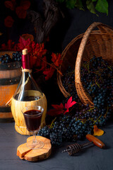 Grapes in the basket with wine and tree leaves