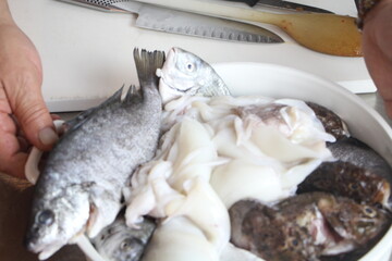 Cucina con cuoco che prepara pesce fresco. Professionale