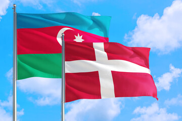 Denmark and Azerbaijan national flag waving in the windy deep blue sky. Diplomacy and international relations concept.