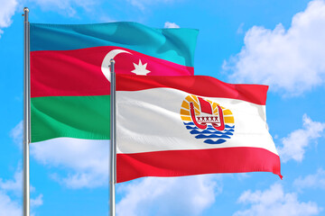 French Polynesia and Azerbaijan national flag waving in the windy deep blue sky. Diplomacy and international relations concept.