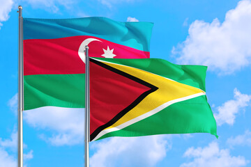 Guyana and Azerbaijan national flag waving in the windy deep blue sky. Diplomacy and international relations concept.