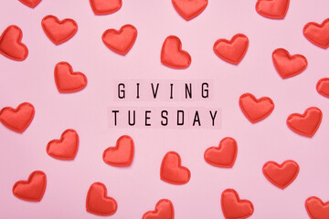 Giving Tuesday text message. Global day of charitable giving after Black Friday shopping day. Red hearts on pink background