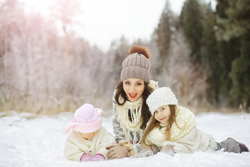 Obraz premium Happy family playing and laughing in winter outdoors in the snow. City park winter day.