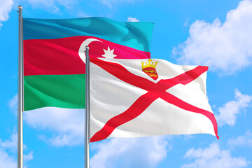 Jersey and Azerbaijan national flag waving in the windy deep blue sky. Diplomacy and international relations concept.