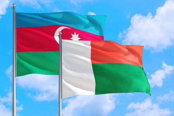 Madagascar and Azerbaijan national flag waving in the windy deep blue sky. Diplomacy and international relations concept.