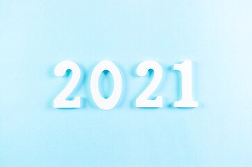 Top view of wooden numbers 2021 on pastel blue background. New year or Christmas concept.