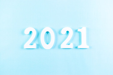 Top view of wooden numbers 2021 on pastel blue background. New year or Christmas concept.