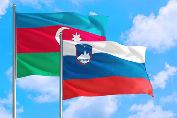 Slovenia and Azerbaijan national flag waving in the windy deep blue sky. Diplomacy and international relations concept.