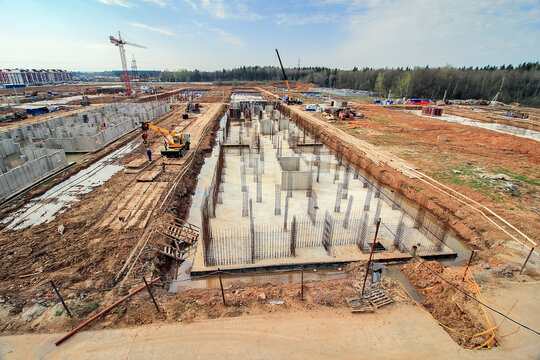 foundation pit for construction of residential building is flooded under water. Flooding construction site. first floor of newly built monolithic apartment house in forest. Ground floor pit in field