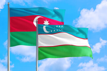 Uzbekistan and Azerbaijan national flag waving in the windy deep blue sky. Diplomacy and international relations concept.