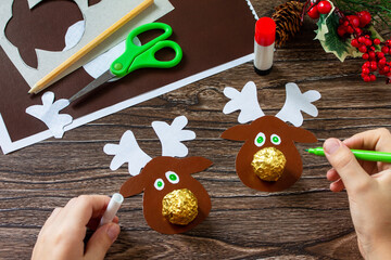 Instruction step 10. Funny Gift with candy Christmas deer on a wooden table. Handmade. Children's creativity project, crafts, crafts for kids. © elena_hramowa