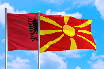 Macedonia and Albania national flag waving in the windy deep blue sky. Diplomacy and international relations concept.
