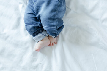 Baby feet on white bed background