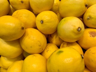 a lot of yellow lemons with small defects in market