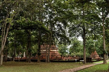 Obraz premium Old pagodas and laterite statues Kamphaeng Phet Historical Park
