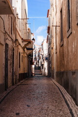 Old, narrow streets, houses of the Portuguese town. The road is lined with paving stones
