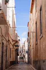 Fototapeta na wymiar Old, narrow streets, houses of the Portuguese town. The road is lined with paving stones