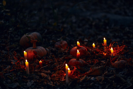 Dark autumn night background with pumpkins and burning candles. Photoshop overlay with candles and pumpkins on Samhain and Halloween