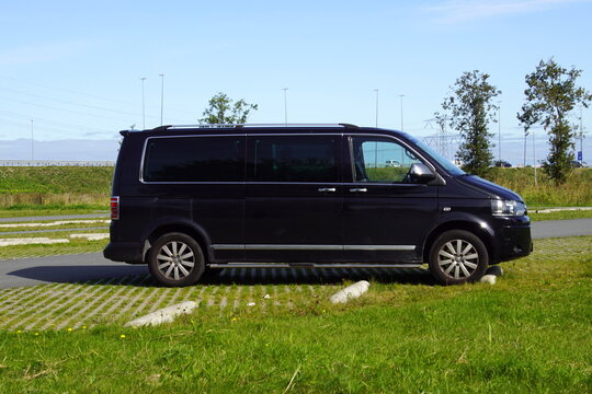Almere, the Netherland - September 20, 2019: Black Transporter surveillance / private detective van with blinded windows parked on a public parking lot.