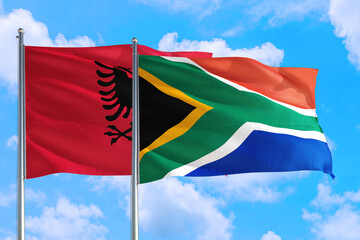 South Africa and Albania national flag waving in the windy deep blue sky. Diplomacy and international relations concept.