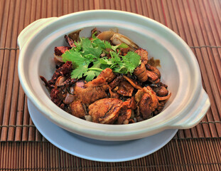 Clay pot Pork Belly with Salted Fish on bamboo mat background.