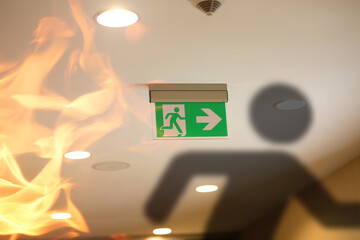 emergency exit sign and fire in the building - 391060927