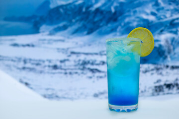 Blue cocktail with ice and lemons in a glass