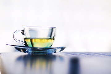 Hot steaming green tea in a cup on a rustic background