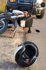 Photo of car, helmet and motorcycle on the road, the concept of road accidents.