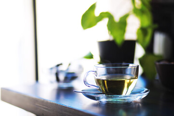Hot steaming green tea in a cup on a rustic background