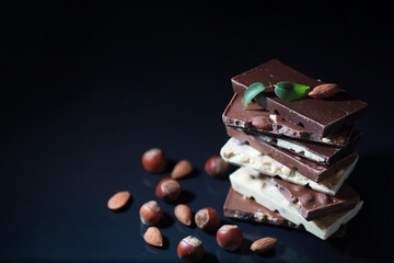 A bar of milk chocolate. Homemade milk chocolate with almonds and dried strawberries. Pieces of milk chocolate. Set of milk chocolate with tea.