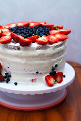 chocolate cake with white cream, strawberries and blueberries