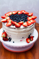 chocolate cake with white cream, strawberries and blueberries